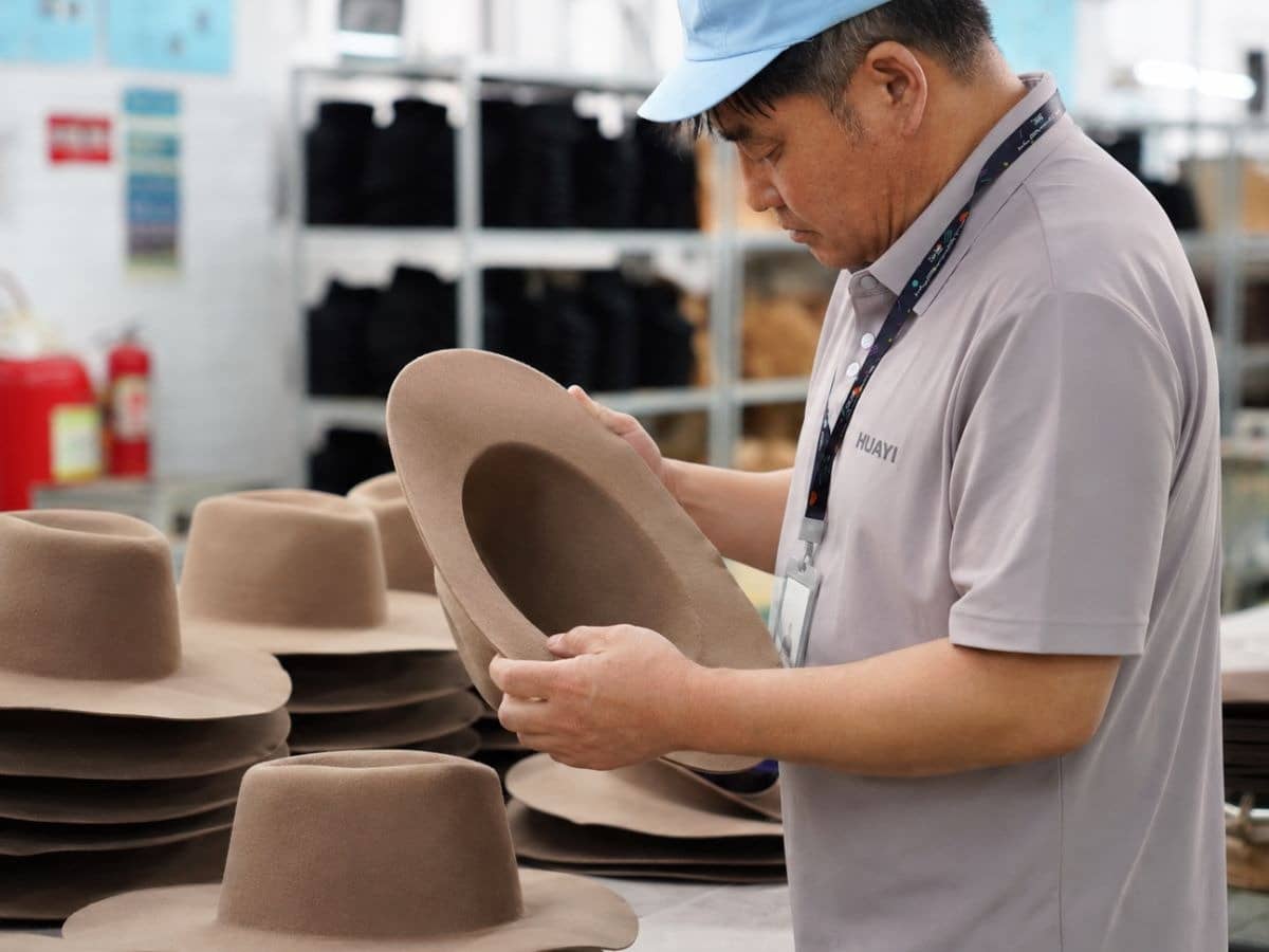 Quality inspector checking a finished hat in the factory